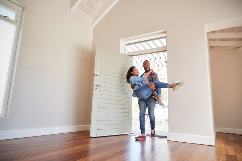 Man Carrying Woman Over Threshold Of Doorway In New Home Man Carrying Woman Over Threshold Of Doorway In New Home