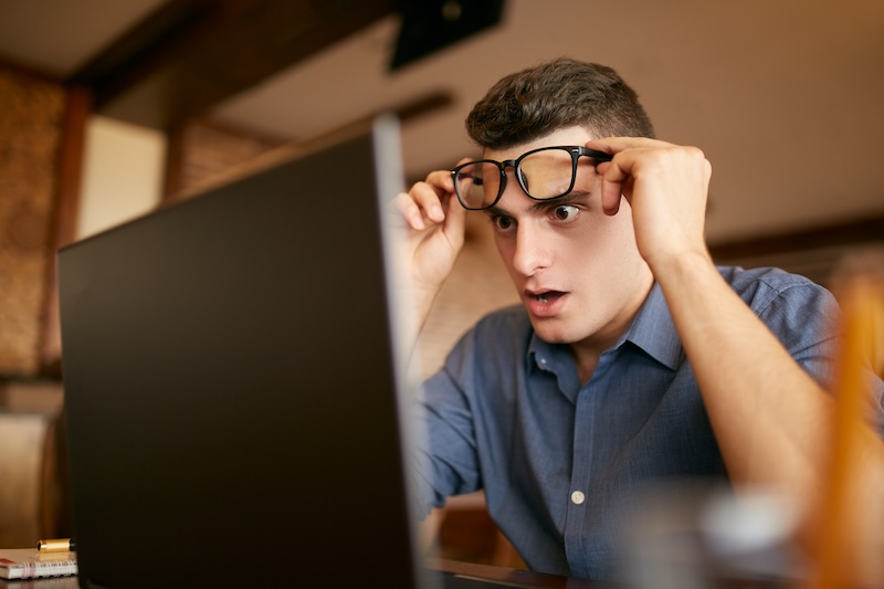 Shocked Freelancer Hipster Man Looks To Laptop Screen And Can Not Believe Unpleasant News. Pop Eyed Frightened Businessman Trader Raises One’s Glasses Above His Eyes. Trader Monitoring Stock Exchange Shocked Freelancer Hipster Man Looks To Laptop Screen And Can Not Believe Unpleasant News. Pop Eyed Frightened Businessman Trader Raises One's Glasses Above His Eyes. Trader Monitoring Stock Exchange